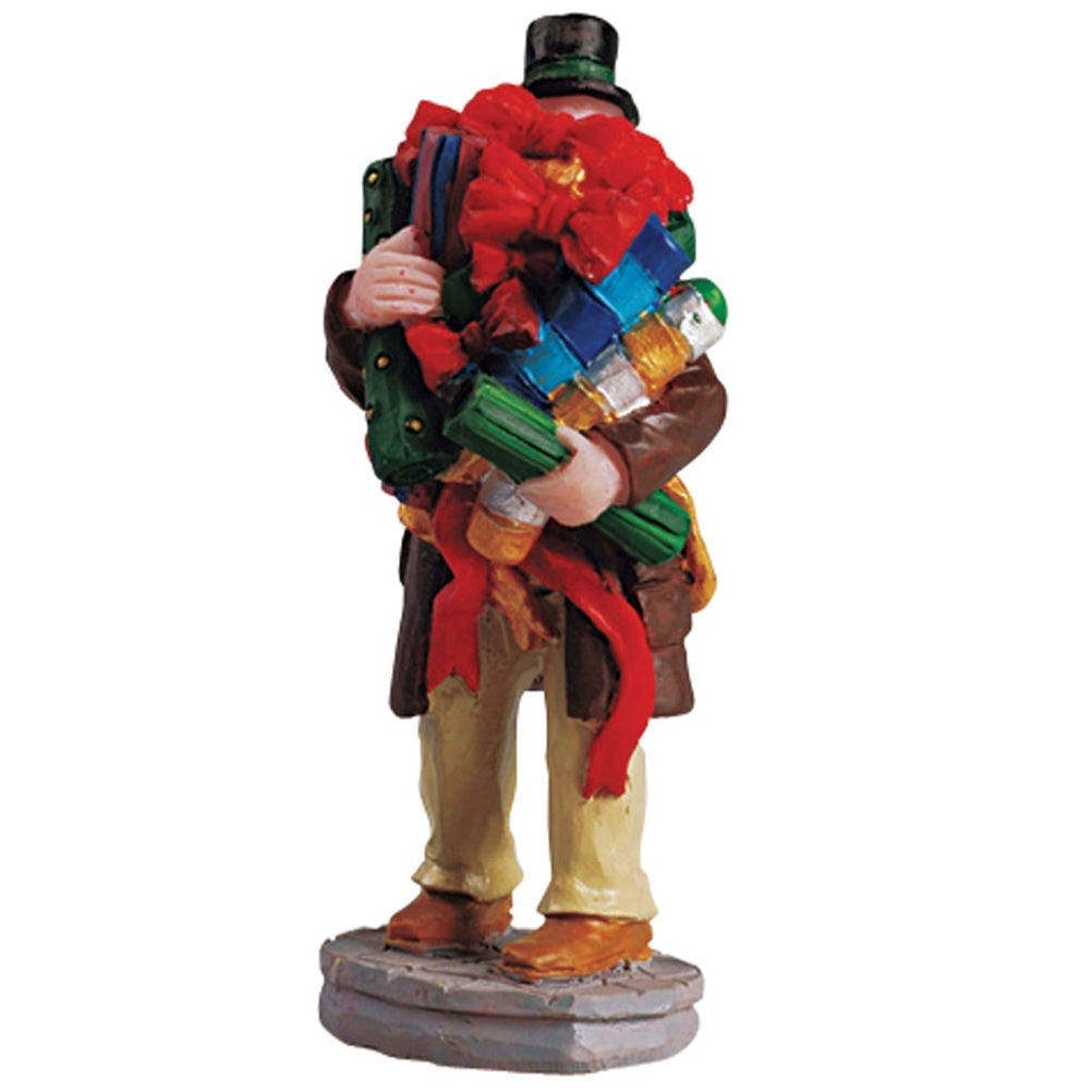 Polyresin figurine for a Lemax display. Designed to look like a person holding too many accessories for wrapping presents.