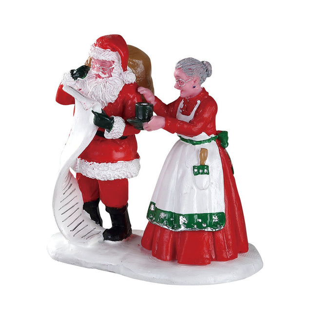 Polyresin figurine for a Lemax display. Designed to look like Santa and Mrs. Claus double checking their list. Mrs. Claus is trying to give Santa a cup of hot chocolate.