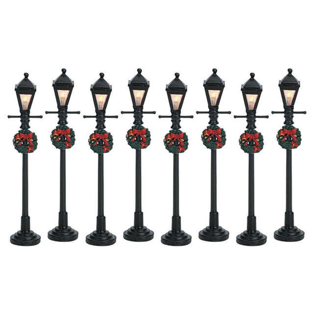 Set of 8 Lemax village lampposts. Each is decorated with a Christmas wreath.