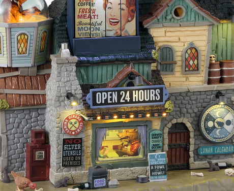Resin lighted building for a Spooky Town Lemax display. Designed to look like a very large diner. There's a giant, circular sign on the roof that reads "THE FULL MOON DINER" and next to it is a round, yellow moon with a silhouette of a werewolf on it. There's a see through globe with a wolf inside and a werewolf eating inside the diner. There's garbage and bones on the sidewalk.