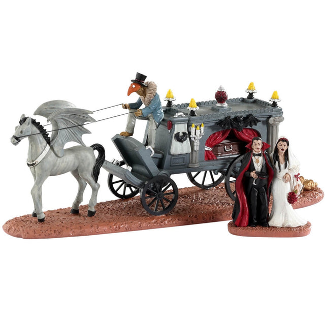 Resin table accent for a Lemax Spooky Town Village display. Designed to look like a wagon carrying a coffin. The wagon is being pulled by a horse with wings. There's a vampire couple that have just gotten married standing outside.