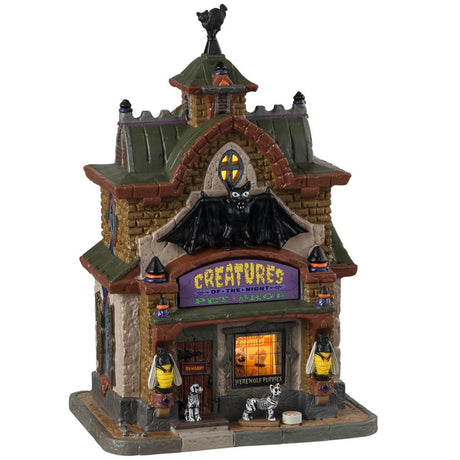 Porcelain lighted building for a Lemax display. Designed to look like a tall pet shop. There are bee statues outside the front. There are skeleton pets waiting to be let inside.