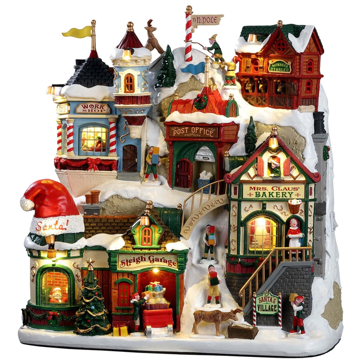 Resin building facade for a Lemax display. Designed to look like a bunch of store fronts decorated for Christmas. The roofs and the sidewalks are covered in snow. There are elves and reindeer and people shopping. There's a window on the left side where you can see Santa inside. There's a work shop, a post office, a sleigh garage, a bakery and some stables.