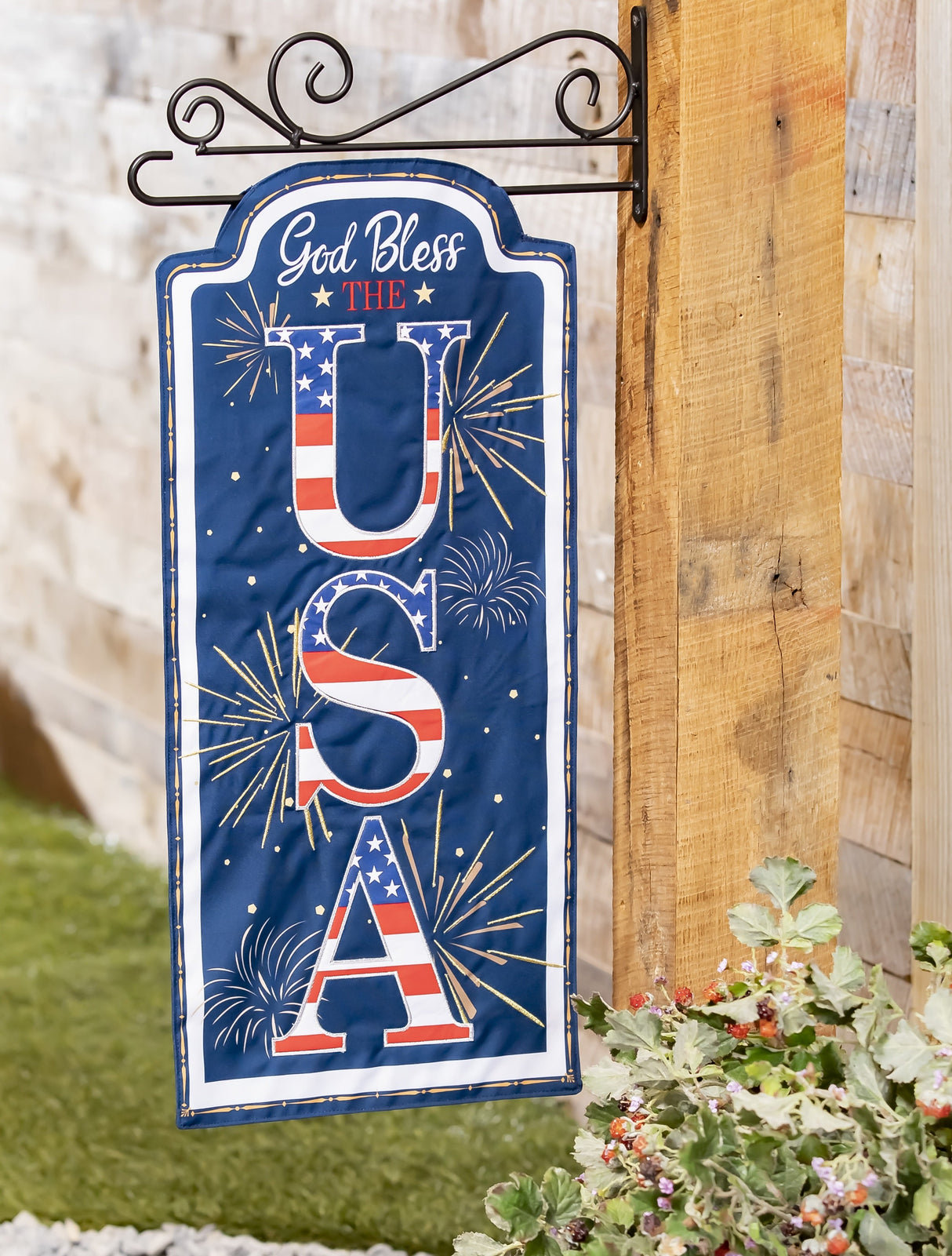 Sign that reads "GOD BLESS THE USA." The background is blue with yellow, white and orange fireworks. The USA is decorated to look like the American flag.