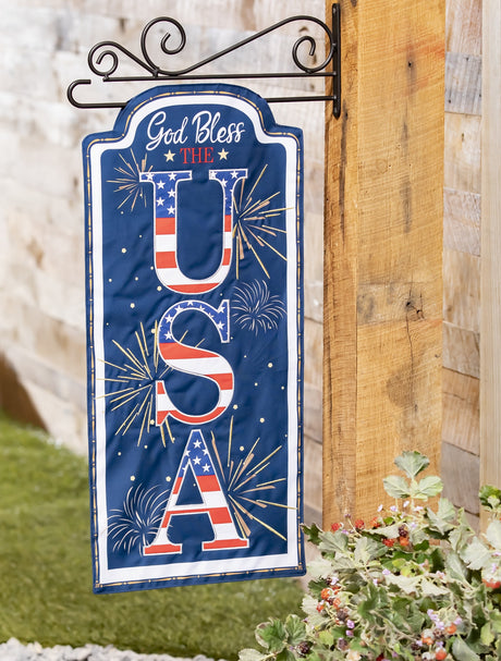 Sign that reads "GOD BLESS THE USA." The background is blue with yellow, white and orange fireworks. The USA is decorated to look like the American flag.