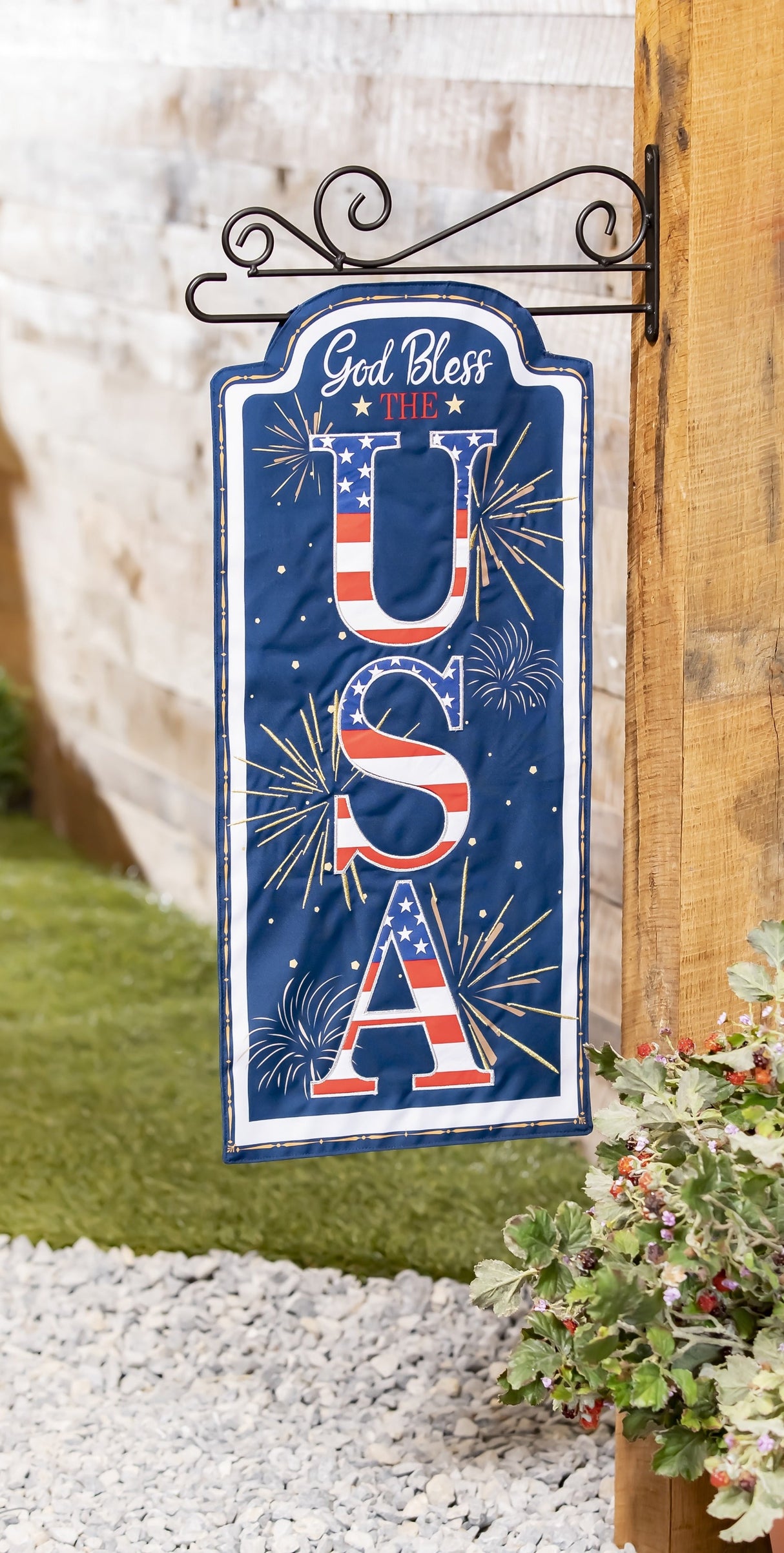 Sign that reads "GOD BLESS THE USA." The background is blue with yellow, white and orange fireworks. The USA is decorated to look like the American flag.
