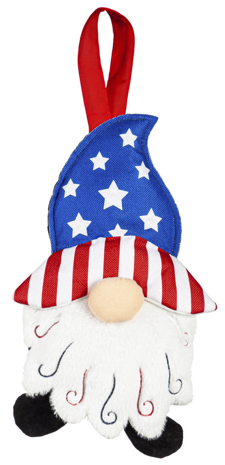 Patriotic hanging decoration designed to look like a gnome with a long, white beard. The gnome is wearing a blue hat with light up stars, the brim of the hat is red and white striped and he's wearing black shoes.