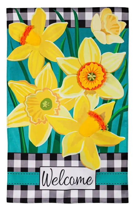 A flag with white and black plaid borders, a bunch of different yellow flowers with a teal background and it reads "Welcome" in cursive