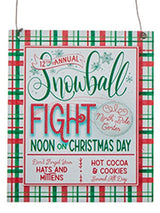 Sign reads "12th Annual Snowball Fight at the North Pole Center. Noon on Christmas Day. Don't forget your hats and mittens. Hot cocoa and cookies served all day."