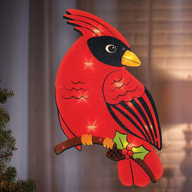 LED holiday decoration shaped like a cardinal standing on a branch with holly leaves, berries and a pine cone.