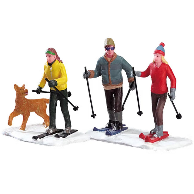 Polyresin figurines for a Lemax display. Designed to look like three adults skiing. There's a dog chasing them.