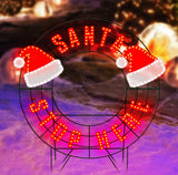 LED outdoor decoration that reads "Santa Stop Here." The text is red. It also features two Santa hats.