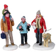 Resin figurines for a Lemax display. One figure is a dad holding a small child on his shoulders. Another figure is a young child holding ice skates. The other figure is of a mom holding ice skates and a dog's leash. The dog is wearing a light blue collar. They're all wearing winter clothes and the ground is snow.