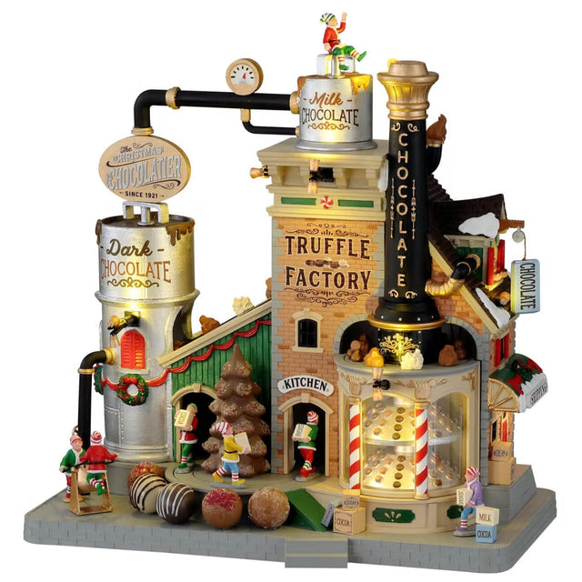 Polyresin lighted building for a Lemax display. Designed to look like a Christmas themed factory. There's an elf sitting on top of the roof. Signs read "Milk Chocolate," "Dark Chocolate," "Truffle Factory, "Kitchen" and "Chocolate." There's a display of truffles in the front window and a bunch of elves working hard.
