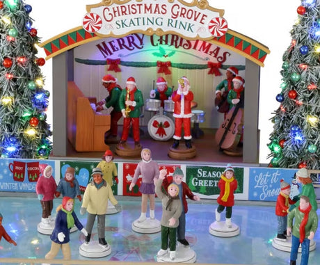 Plastic, animated figure for a Lemax display. Designed to look like an ice skating rink. There are a bunch of people skating around. There's a band on the stage in Christmas outfits and Santa hats. The sign on the stage reads "Christmas Grove Skating Rink. Merry Christmas." There are two tall, decorated Christmas trees on either side of the stage.