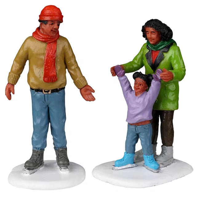 Resin figurines for a Lemax display. Designed to look like a mom, a dad and a young girl ice skating. They're all wearing winter clothes and smiling.