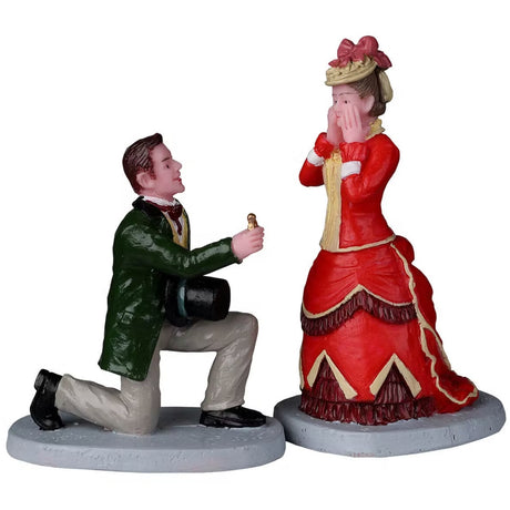 Resin figurines for a Lemax display. Designed to look like a man proposing to a woman. They're both wearing old Victorian clothes. She has her hands on her face like she's surprised.