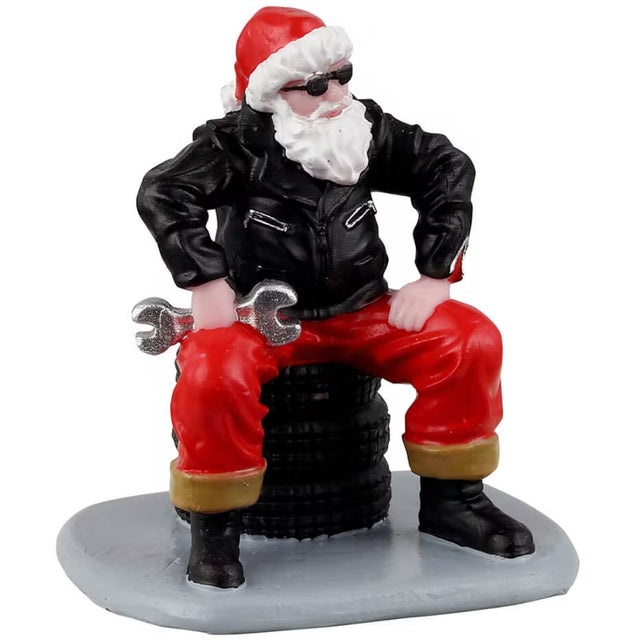 Resin figurine for a Lemax display. Designed to look like Santa dressed as a mechanic. He's wearing a leather jacket and sunglasses. Santa is sitting on a stack of tires and holding a wrench.