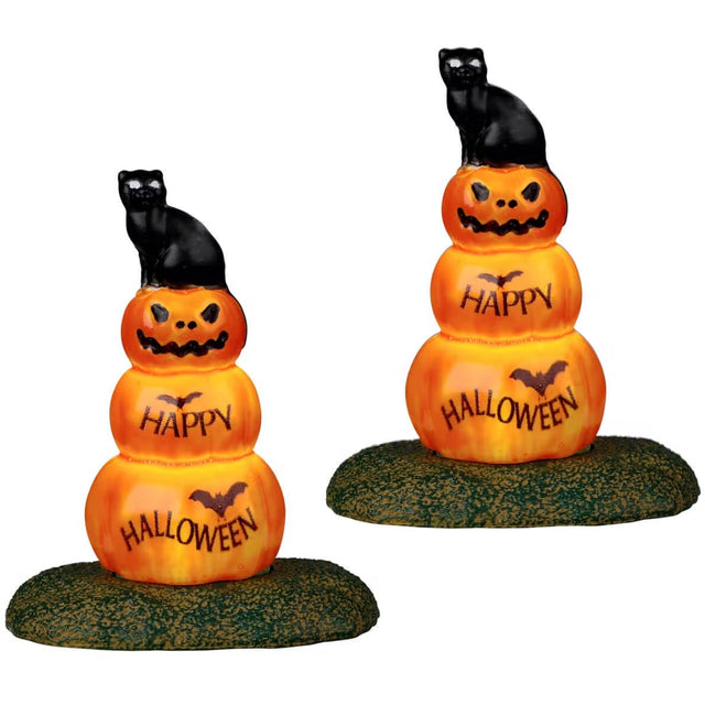 Resin village accents for a Spooky Town Lemax display. Designed to look like two stacks of three pumpkins. The top pumpkin is a jack-o-lantern. The second pumpkin reads "HAPPY" and has a bat on it. The third pumpkin reads "HALLOWEEN" and has a bat on it. The pumpkins are stacked on top of each other like a snowman.