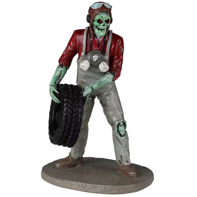 Polyresin figurine for a Spooky Town Lemax display. Designed to look like a skeleton mechanic holding a tire. He's wearing a brown cap with goggles on top, a red shirt, gray overalls and brown shoes. The skeleton is lime green.