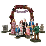 Resin figurines for a Lemax display. Designed to look like a zombie family getting their picture taken underneath a wooden arch with roses all over it. There's a bride, a groom, a maid of honor, a best man, a young boy and a young girl.