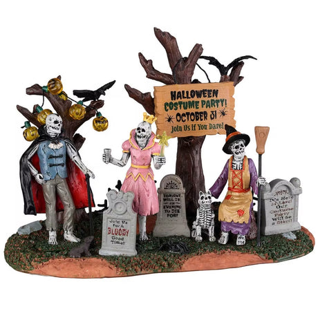 Resin village accent for a Lemax Spooky Town display. Designed to look like three skeletons wearing costumes in a graveyard. One skeleton is dressed like a vampire, one skeleton is dressed like a princess and the other skeleton is dressed like a witch and is petting a skeleton dog. The trees are decorated with pumpkin lights and there are black crows sitting on some branches.