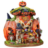 Resin building for a Lemax Spooky Town display. Designed to look like a building made out of a pumpkin. There are jack-o-lanterns everywhere, candy, spiders, candy corn and witch hats. There's a sign on the side that reads "WITCH'S BREW" and underneath is a spout shooting out green and pink liquid. There's a sign next to it that reads "TOXIC."