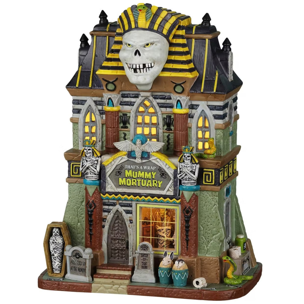 Porcelain lighted building for a Lemax display. Designed to look like a tall, light green building with an Egyptian mummy statue on the roof. There are skeletons, tombstones and snakes.