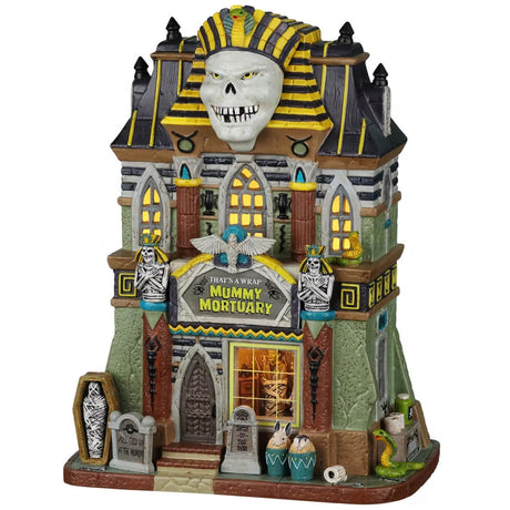 Porcelain lighted building for a Lemax display. Designed to look like a tall, light green building with an Egyptian mummy statue on the roof. There are skeletons, tombstones and snakes.