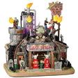 Resin lighted building for a Lemax display. Designed to look like a rusty, old gas station. There are monsters working there and tombstones out front. The lights on the roof are actually torches.