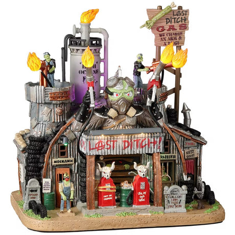 Resin lighted building for a Lemax display. Designed to look like a rusty, old gas station. There are monsters working there and tombstones out front. The lights on the roof are actually torches.