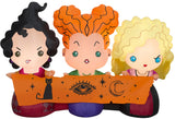Halloween inflatable decoration designed to look like the three Sanderson sisters from the movie Hocus Pocus. They're all wearing their iconic witch outfits and holding a scroll with a cat, an eye and a crescent moon on it.