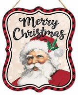 This sign reads "MERRY CHRISTMAS" in black cursive. The border is red and black buffalo check. The background is a light tan color with white polka dots and a smiling Santa Claus.