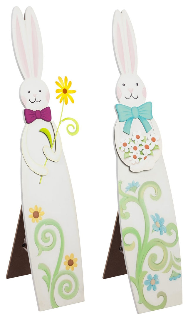 A porch decoration shaped like a tall bunny. One bunny is wearing a pink bow and holding a yellow flower and features two yellow flowers at the base. One bunny is wearing a teal bow and holding a bunch of white flowers and features four blue flowers at the base