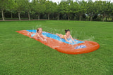 A slip n slide with two lanes that lead into a splash pad.