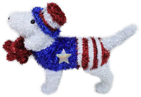 Patriotic tinsel tabletop decoration shaped like a dog holding a red star in its mouth. The dog is wearing a red, white and blue top hat and a red, white and blue jumper with a holographic star on the side.