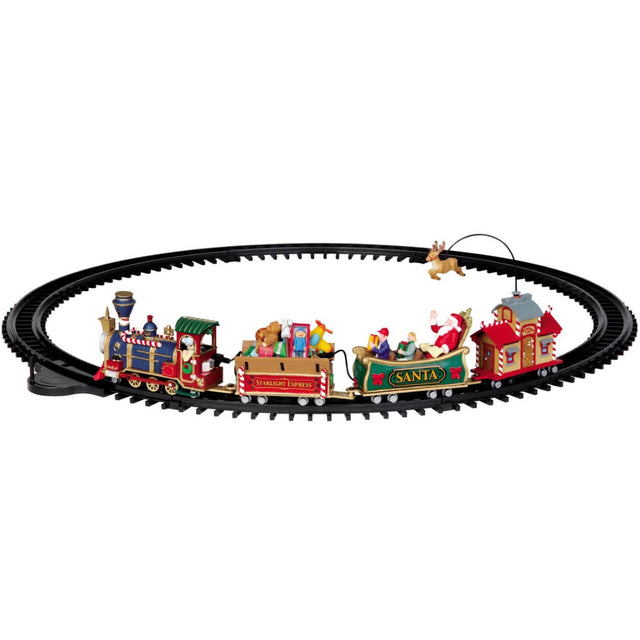 Plastic train on plastic tracks for a Lemax Village tabletop display. The train is Christmas themed