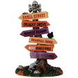 Polyresin figure for a Lemax display. Designed to look like a roadway sign with arrows pointing in different directions. There's a skull and cross bones on top. The signs read Skull Street, Deadly Drive, Haunted Highway, Roadkill Road, Boo Boulevard and Wicked Witch Way. There are a couple rats at the base.