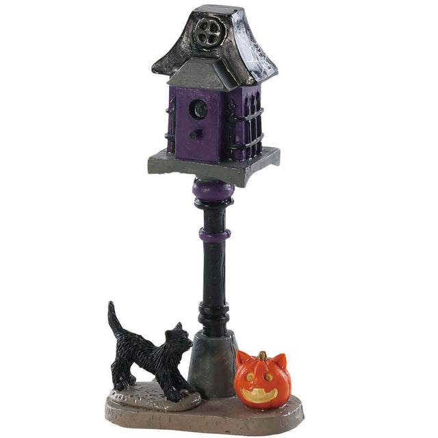 Polyresin figure for a Lemax display. Designed to look like a spooky, black and purple birdhouse. There's a spiderweb on the top, a black cat and a pumpkin at the bottom.
