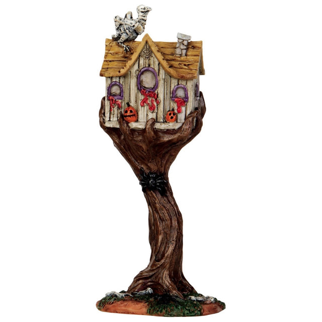 Polyresin figure for a Lemax display. Designed to look like a spooky treehouse. There's a skeleton bird on the roof and jack-o-lanterns. There's blood dripping from the windows and a spider climbing up the tree.