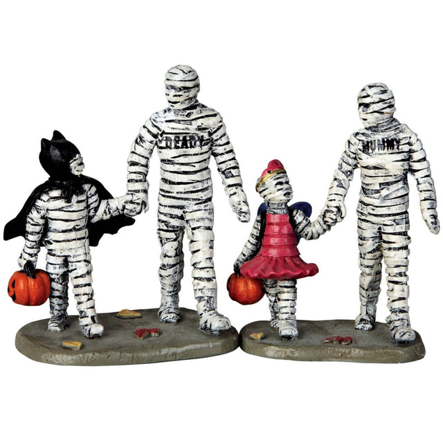 Polyresin figurines for a Lemax display. Designed to look like a mommy and daddy mummy trick or treating with a young boy mummy and young girl mummy. The little boy mummy is dressed like Batman and the little girl mummy is dressed like a ballerina.