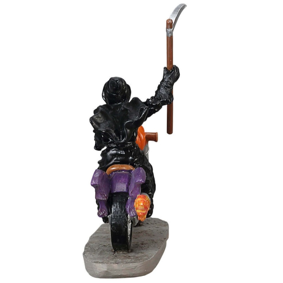 Polyresin figurine for a Lemax display. Designed to look like the Grim Reaper riding a purple motorcycle. There's a pumpkin on the front of the motorcycle. The Grim Reaper is holding a scythe.