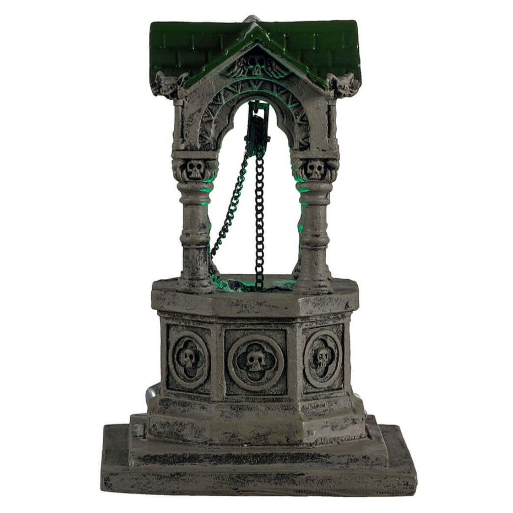 Plastic village accent for a Lemax display. Designed to look like an old, gothic well. The well is decorated with skulls, gargoyle heads and chains. There's a green light coming from inside.