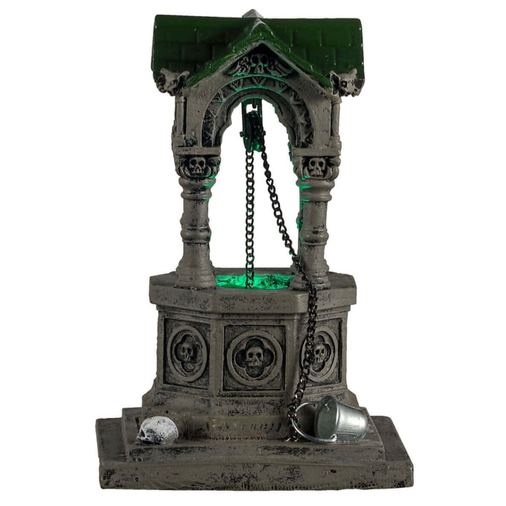 Plastic village accent for a Lemax display. Designed to look like an old, gothic well. The well is decorated with skulls, gargoyle heads and chains. There's a green light coming from inside.