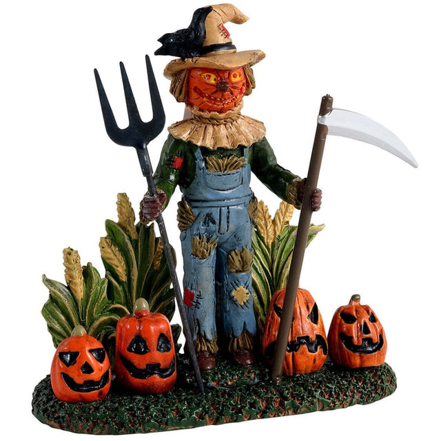 Polyresin figurine for a Lemax Spooky Town display. Designed to look like a scarecrow with a jack-o-lantern face. There are stalks of corn and jack-o-lanterns behind the scarecrow. The scarecrow is wearing jean overalls and is holding a pitchfork scythe. The scarecrow is wearing a hat with a raven on it.