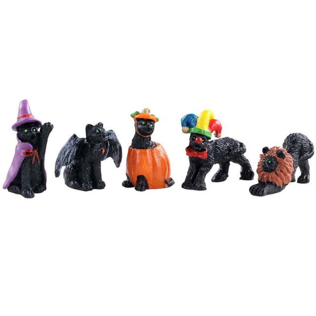 Polyresin figurines for a Lemax display. Designed to look like five black cats wearing costumes. One cat is wearing a purple cape and a purple witch hat. One cat is wearing black wings. One cat is wearing a pumpkin costume. One cat is wearing a jester hat and a red bow tie. One cat is wearing a lion mane.