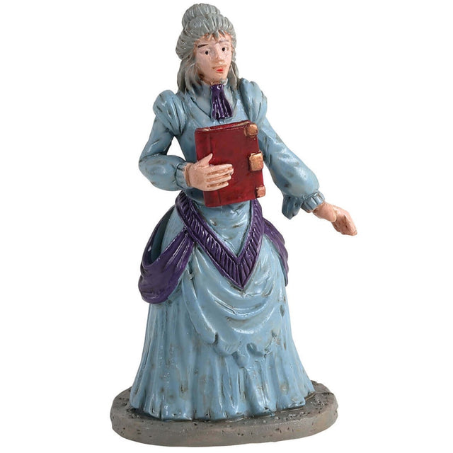 Polyresin figurine for a Lemax display. Designed to look like a woman wearing a light blue, Victorian-era style dress. She's holding a red diary.