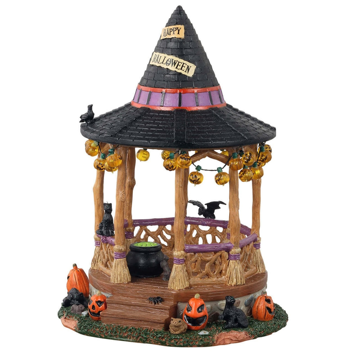 Polyresin village accent for a Lemax display. Designed to look like a wooden gazebo. The roof is shaped like a witch's hat and there's a sign that reads "HAPPY HALLOWEEN!" There are lights hanging from the roof that are shaped like jack-o-lanterns. There's a bat, a crow and a black cat. There's a cauldron with green potion inside. There are pumpkins around it and a toad. The columns of the gazebo are shaped like broomsticks.