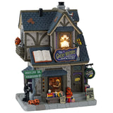 Porcelain lighted building for a Lemax display. Designed to look like a house that's been turned into a bookstore. There are skeletons reading, a Grim Reaper on the sidewalk and a shelf of books for sale outside. 