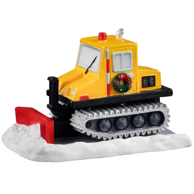 Polyresin figure for a Lemax display. Designed to look like a yellow and black snow plow. There's a decorated wreath on the door. The moldboard (the actual shovel on the snow plow) is a bright red color.